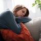 Depressed young woman resting on sofa, feeling unwell or tired, indoor emotional health concept, relaxation and wellness, comfort at home.