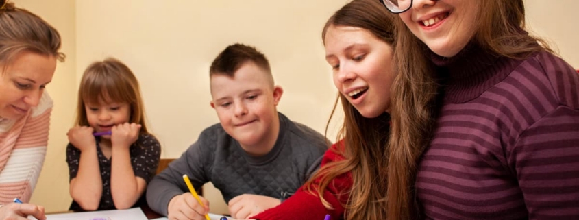 Coloratisti bambini che partecipano a un'attività artistica con pennarelli, in un ambiente educativo per bambini con disturbi dello sviluppo, promuovendo inclusione e terapia occupazionale.